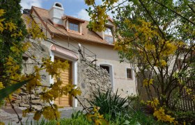 Steinhaus mit gelben Blumen im Vordergrund in D&uuml;rnstein.