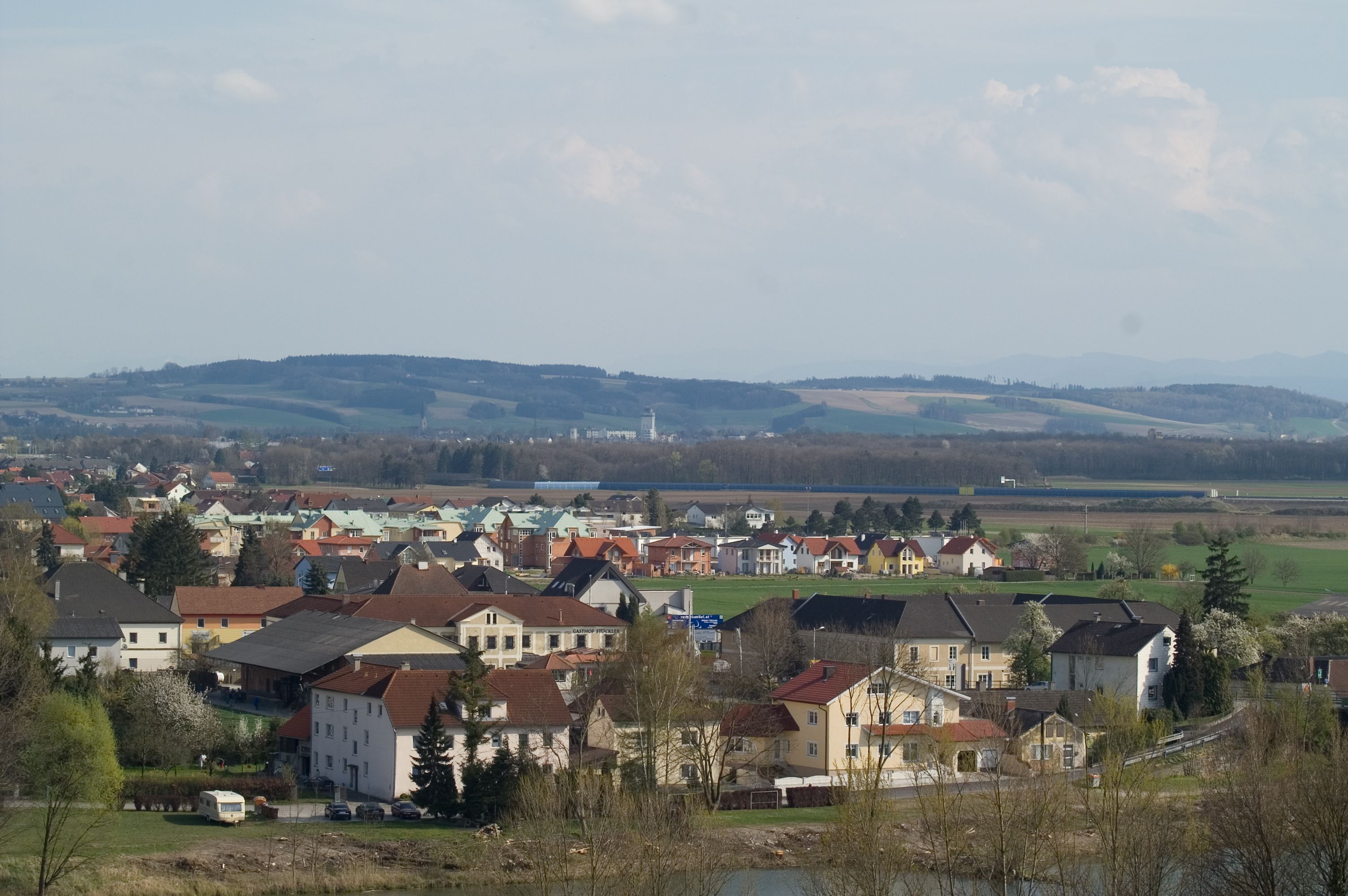 Panoramablick auf Ennsdorf mit Häusern und Hügeln im Hintergrund.