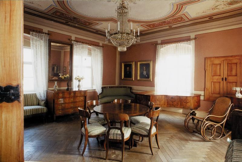 Elegantes Wohnzimmer im Hugo Wolf Haus mit antiken Möbeln und Kronleuchter.