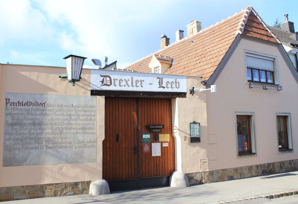 Traditionelles Gebäude mit Schild 'Drexler-Leeb' und Holztor.