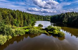 Umgeben von üppigem Grün und dem sanften Plätschern des Wassers, lädt die malerische Landschaft zu einem entspannten Aufenthalt ein. Die Wolken spiegeln sich im ruhigen Wasser und schaffen eine harmonische Atmosphäre, die zum Verweilen einlädt. Hier, wo Natur und Kultur aufeinandertreffen, wird jeder Moment zum unvergesslichen Erlebnis.