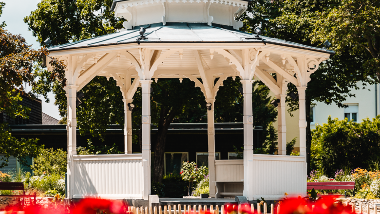 Wei&szlig;er Pavillon vor bl&uuml;henden roten Blumen