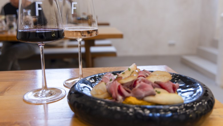 Rotwein und Wei&szlig;weinglas und Heurigenplatte