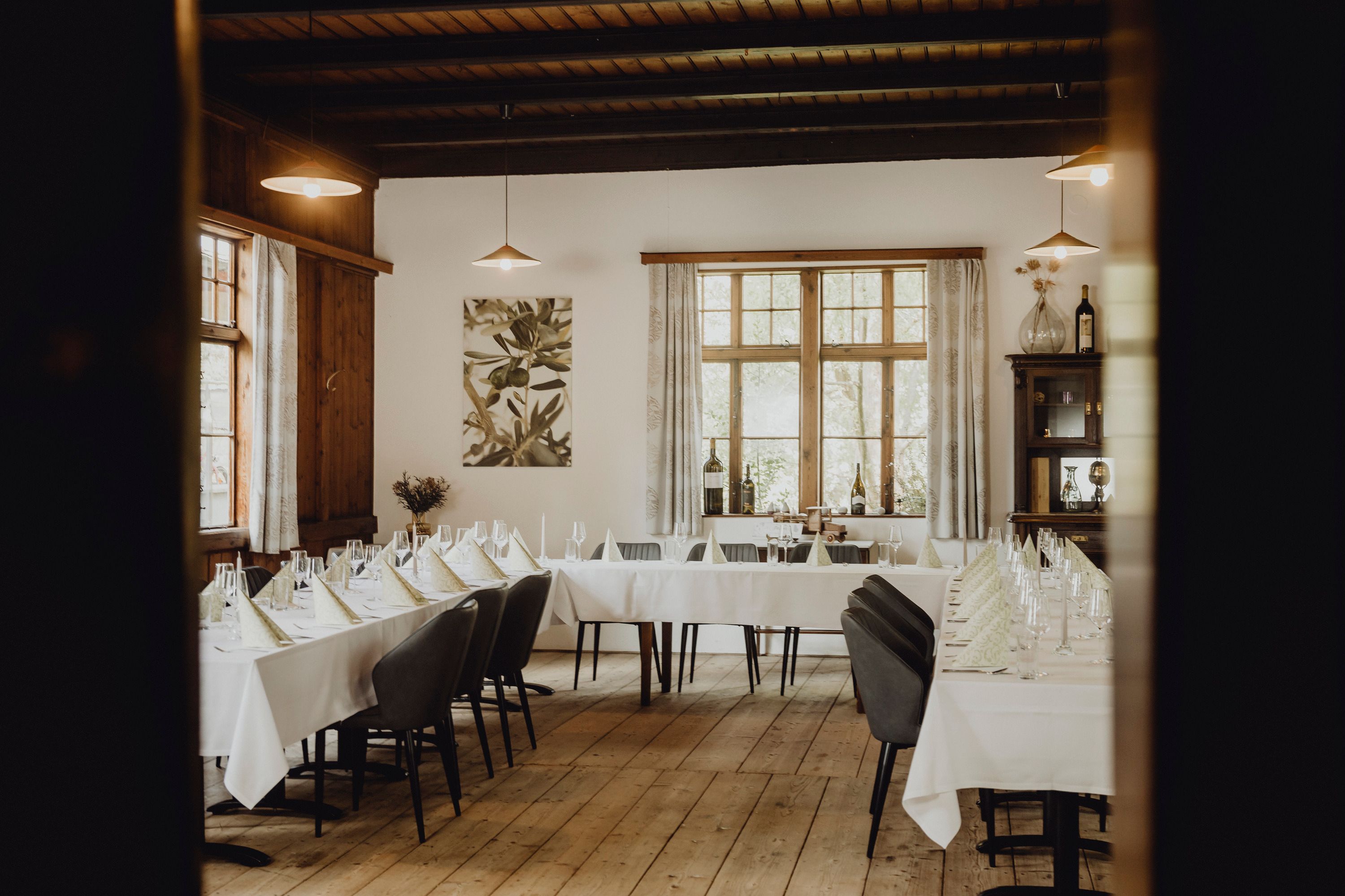 Elegantes Restaurant mit gedeckten Tischen und Holzboden.