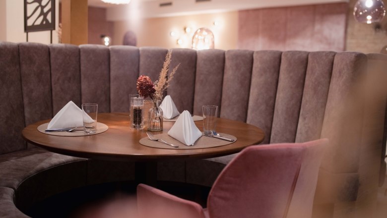 Elegantes Restaurant mit runder Sitzbank und gedecktem Tisch.