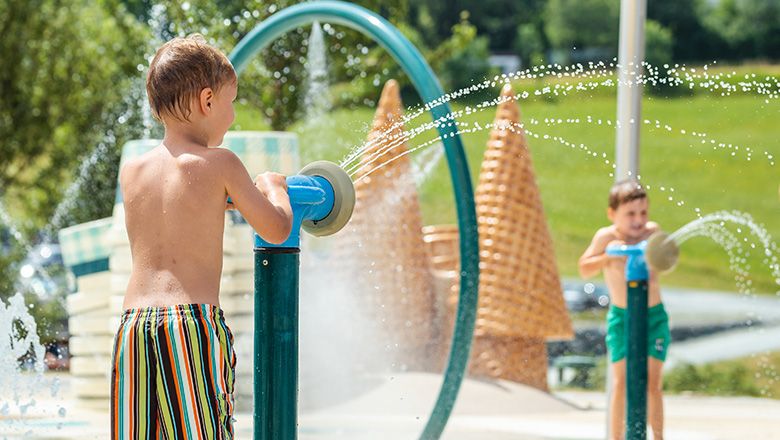 Zwei Kinder in Badekleidung spielen in der Wasserwelt des Eis-Greissler Erlebnisparks.