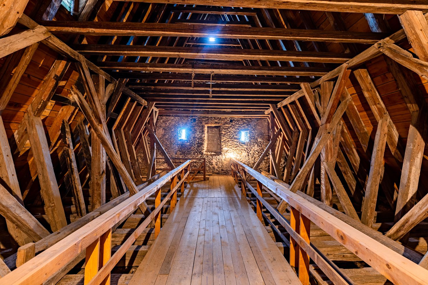 Innenansicht des Obergeschosses der Wehrkirche Lichtenegg mit Holzbalken und Steinfassade.