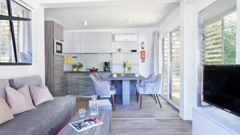 Mobilheim von innen mit hellen M&ouml;beln und Wohnk&uuml;che