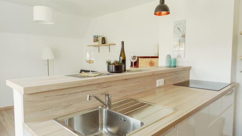 Moderne Küche mit Holzarbeitsplatte, Spüle und Dekoration.