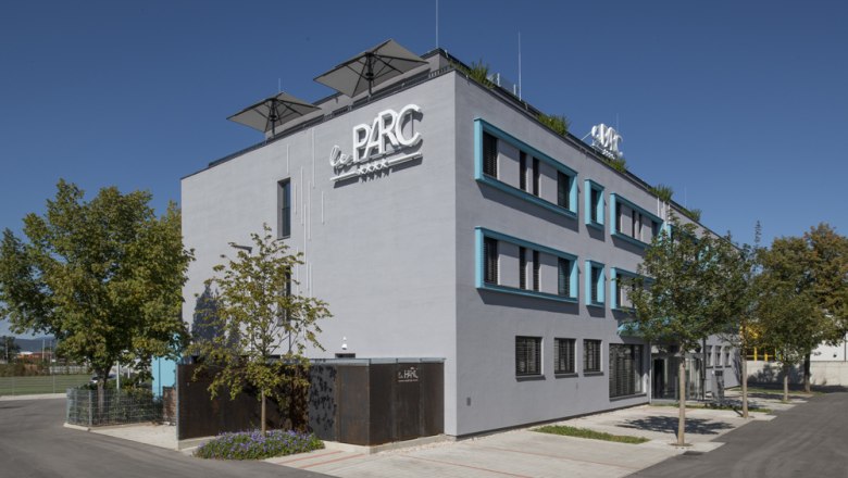 Hotel leParc**** Hausansicht, © Pia Odorizzi Modernes Gebäude mit der Aufschrift 'Le Parc' und Bäumen im Vordergrund.