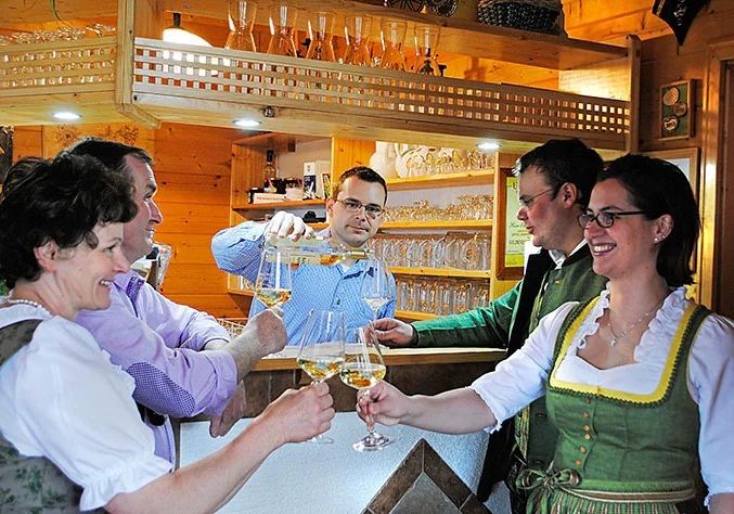 Menschen stoßen an einer gemütlichen Theke mit Getränken an.