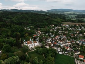 Umgeben von sanften H&uuml;geln und &uuml;ppigem Gr&uuml;n l&auml;dt die malerische Landschaft zu unvergesslichen Wanderungen ein. Die charmanten H&auml;user und die beeindruckende Architektur des Schlosses verleihen der Umgebung eine besondere Atmosph&auml;re, die zum Verweilen einl&auml;dt.
