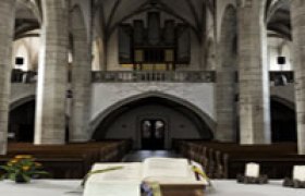 Innenansicht einer Kirche mit Altar und Orgel im Hintergrund.