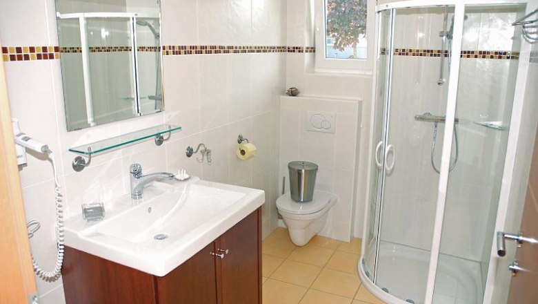 Modernes Badezimmer mit Dusche, Waschbecken und Toilette.