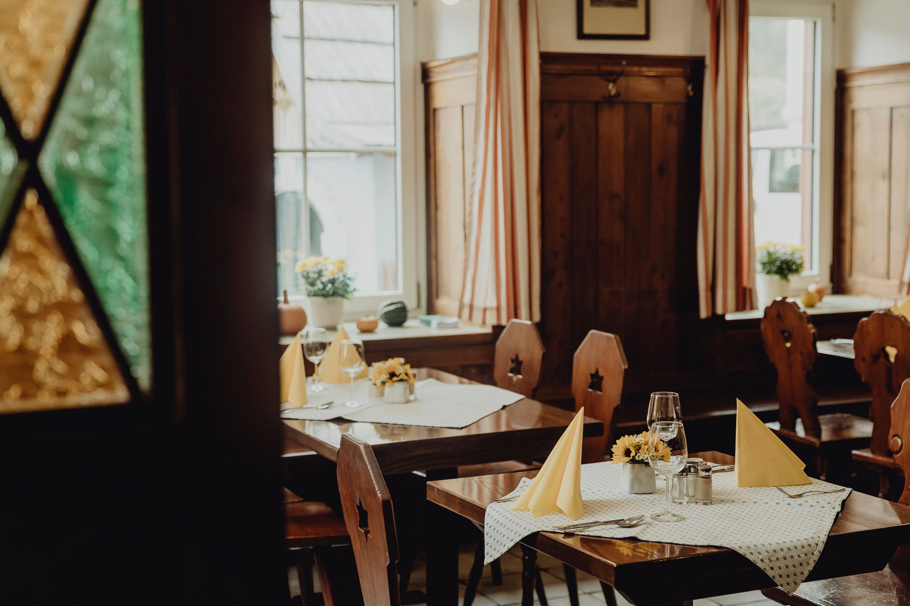 Gemütliches Restaurant mit Holzmöbeln und gedeckten Tischen.