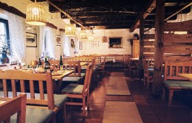 Gem&uuml;tlicher Innenraum eines traditionellen Heurigen mit Holzm&ouml;beln und gedeckten Tischen.