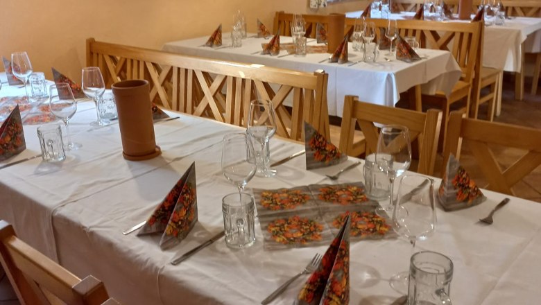 gedeckte Tische innnen mit wei&szlig;er Tischdecke und Servietten