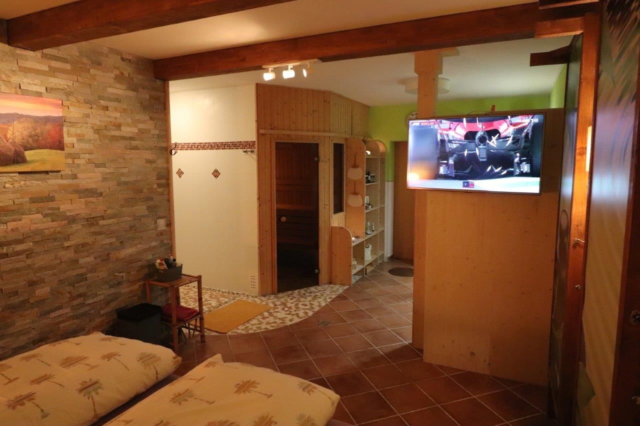 Gästezimmer mit Doppelbett und TV an der Wand 