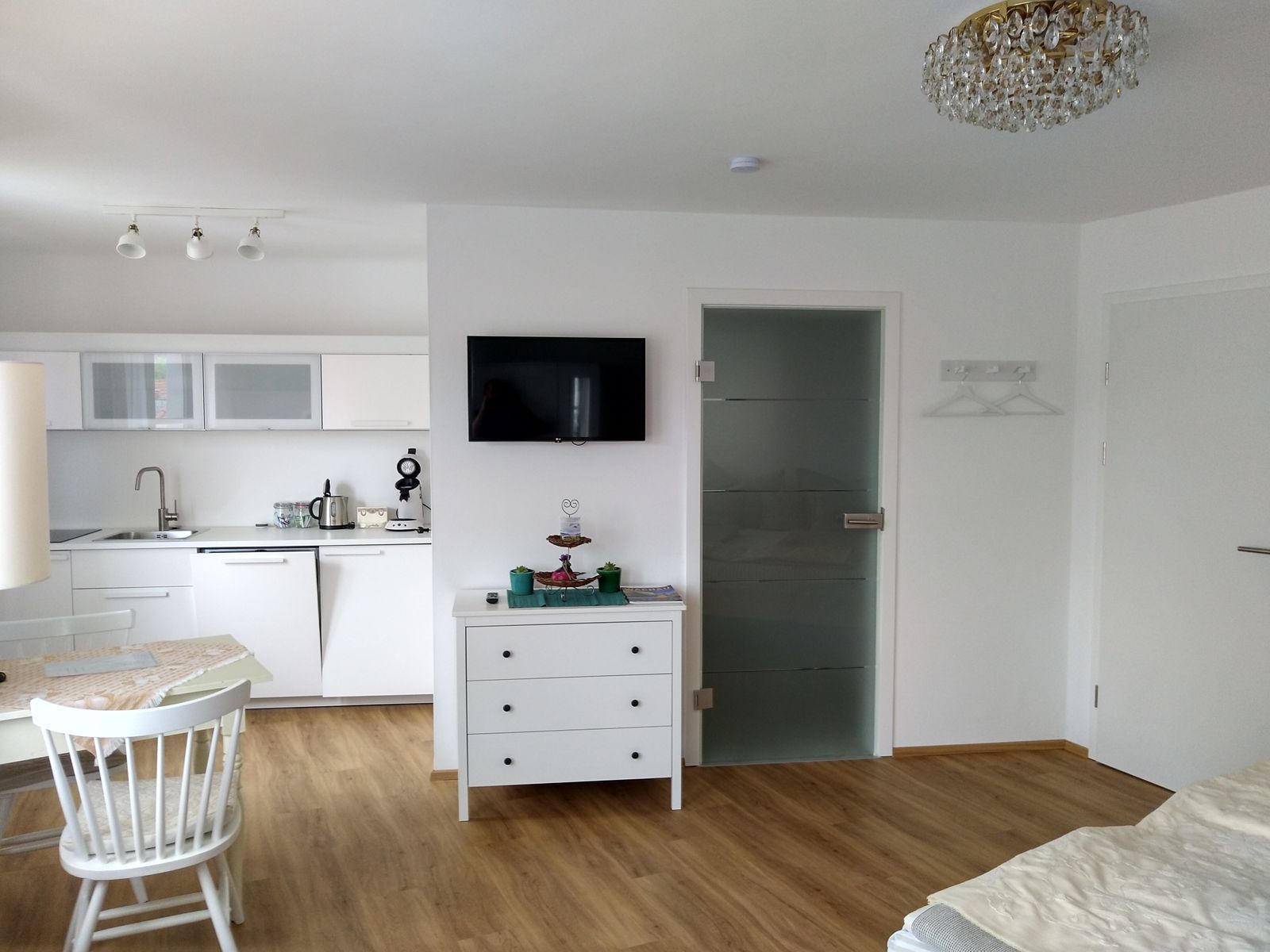 Modernes Apartment mit Küche, Esstisch und Fernseher.