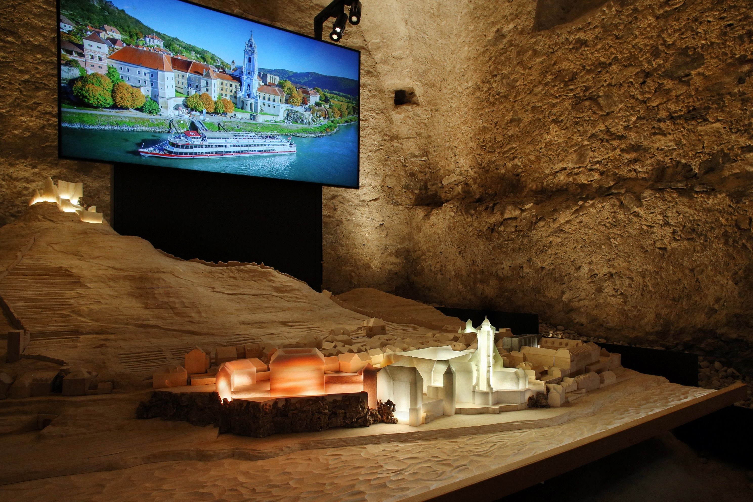 Modell von Dürnstein mit beleuchtetem Stift und Foto im Hintergrund.