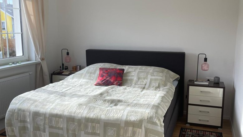 Schlafzimmer, © Regina Schimmer Ein Schlafzimmer mit einem Doppelbett, zwei Nachttischen und Teppichen auf Holzboden.