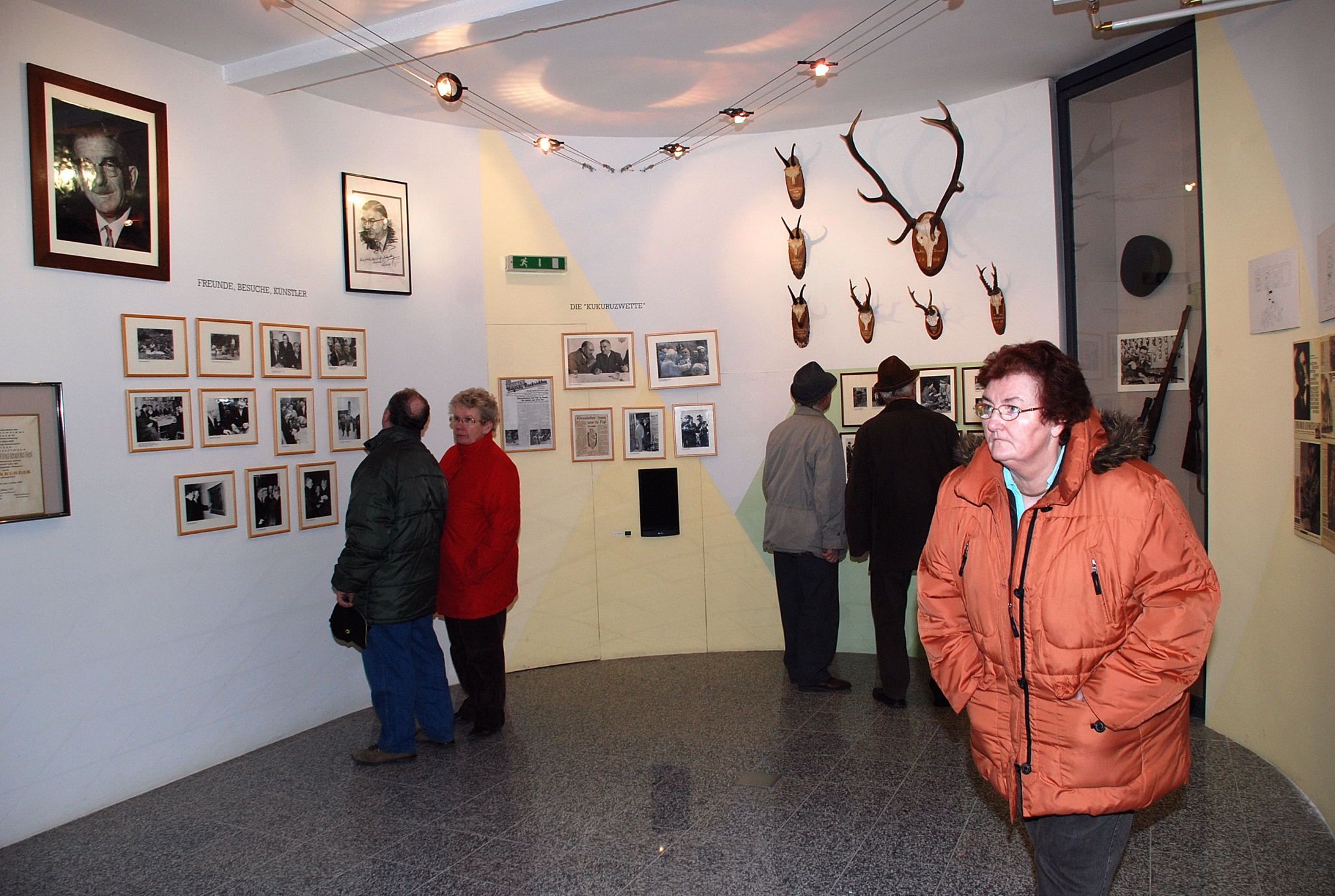 Besucher im Leopold Figl Museum betrachten Fotos und Jagdtrophäen an den Wänden.