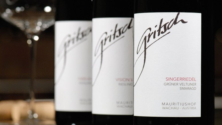 Drei Weinflaschen von FJ Gritsch mit Etiketten in Nahaufnahme.