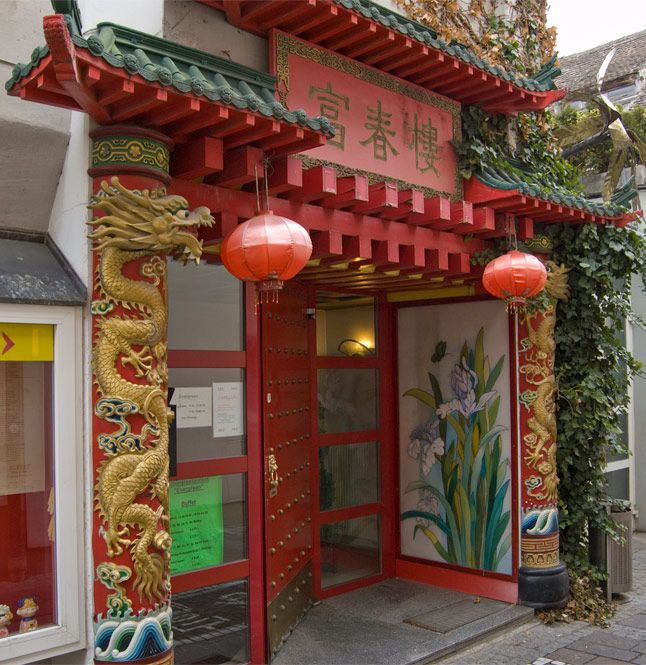 Chinesischer Eingang mit roten Laternen und Drachenverzierungen.