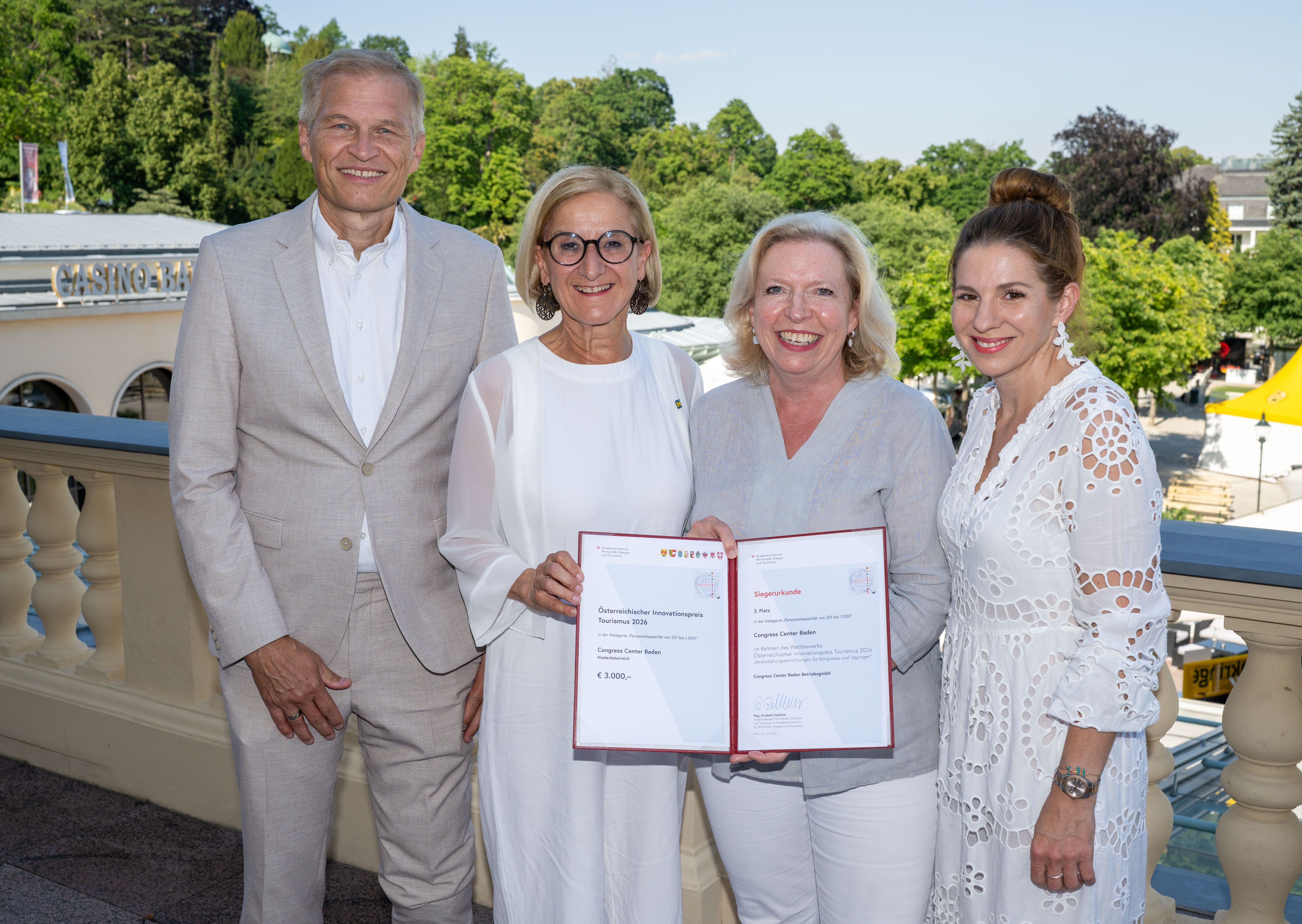 4 Personen mit der Urkunde auf der Terrasse des Congress Center Baden