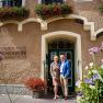 Familie Wildeis steht vor einem historischen Gebäude mit Blumen und der Aufschrift 'Kirchenwirt Restaurant Wachau'.