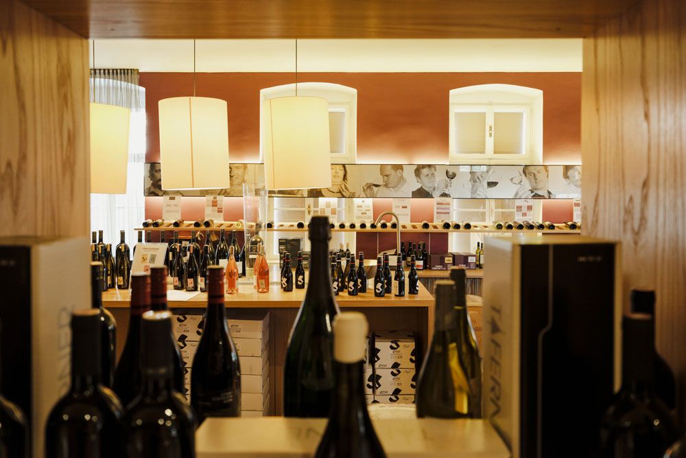 Innenansicht einer Vinothek mit Weinflaschen und dekorativen Lampen.