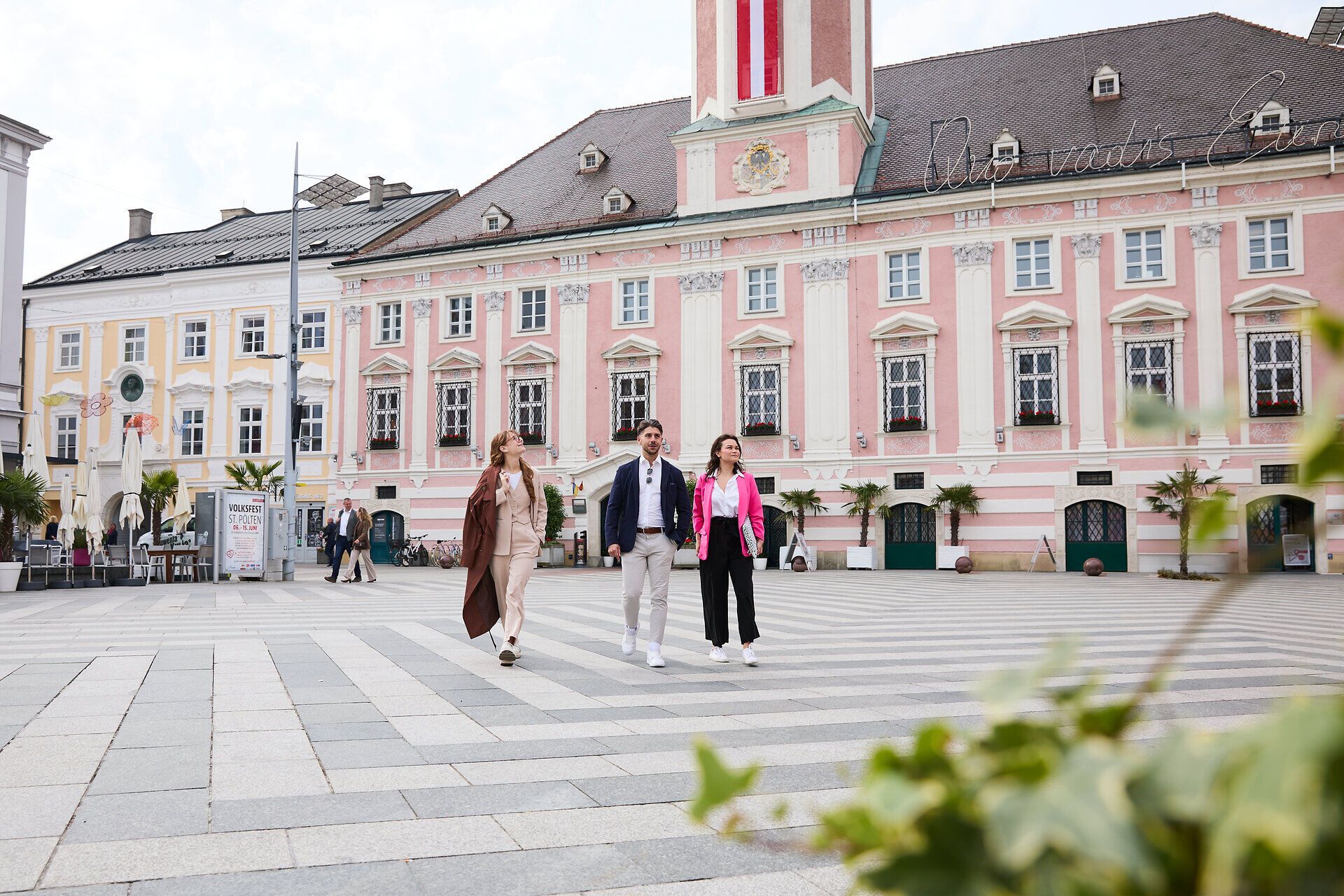 Personen spazieren auf Rathausplatz in St.Pölten.