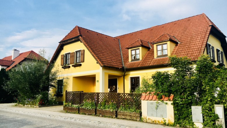 Landhaus Weinblick, © Fam. Ritz Gelbes Landhaus mit rotem Ziegeldach und Garten.