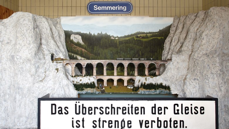 Modell des Kalte Rinne-Viadukts mit Zug und Landschaft im Hintergrund. Schild mit Aufschrift: 'Das &Uuml;berschreiten der Gleise ist streng verboten.'