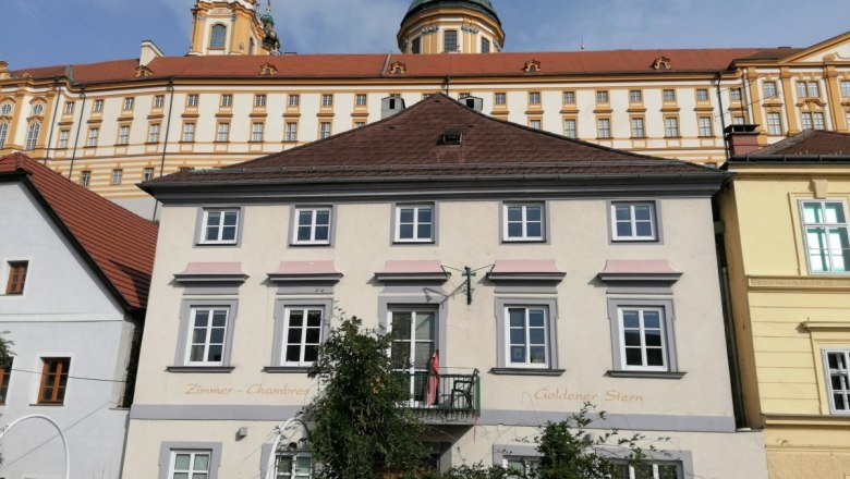 Außenansicht des Aparthotels Goldener Stern mit historischem Gebäude im Hintergrund.