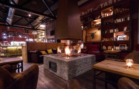 Gemütlicher Raum mit Kamin, Holzmöbeln und Bücherregalen.