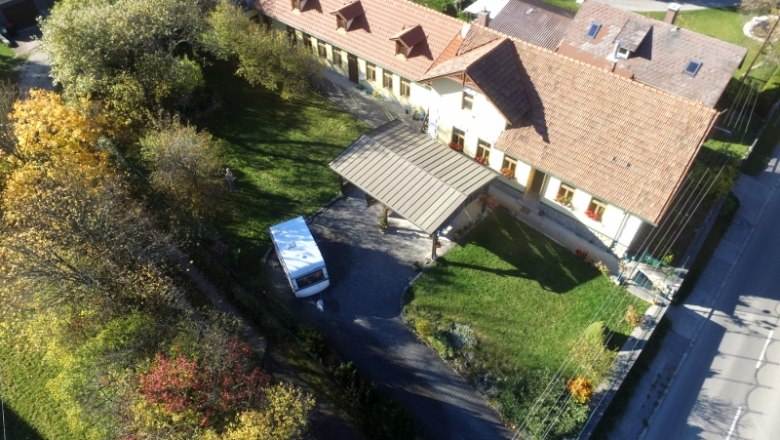 Luftaufnahme eines Hauses mit Garten und Ferienwohnungen im hinteren Teil.