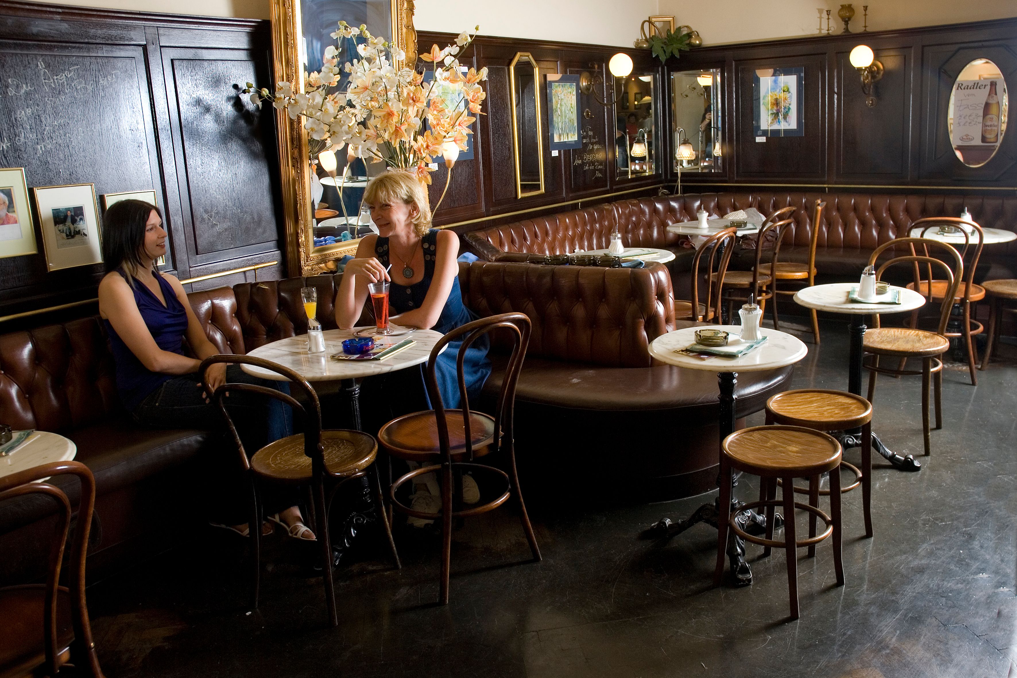 Innenansicht eines traditionellen Cafés mit zwei Frauen, die an einem Tisch sitzen.