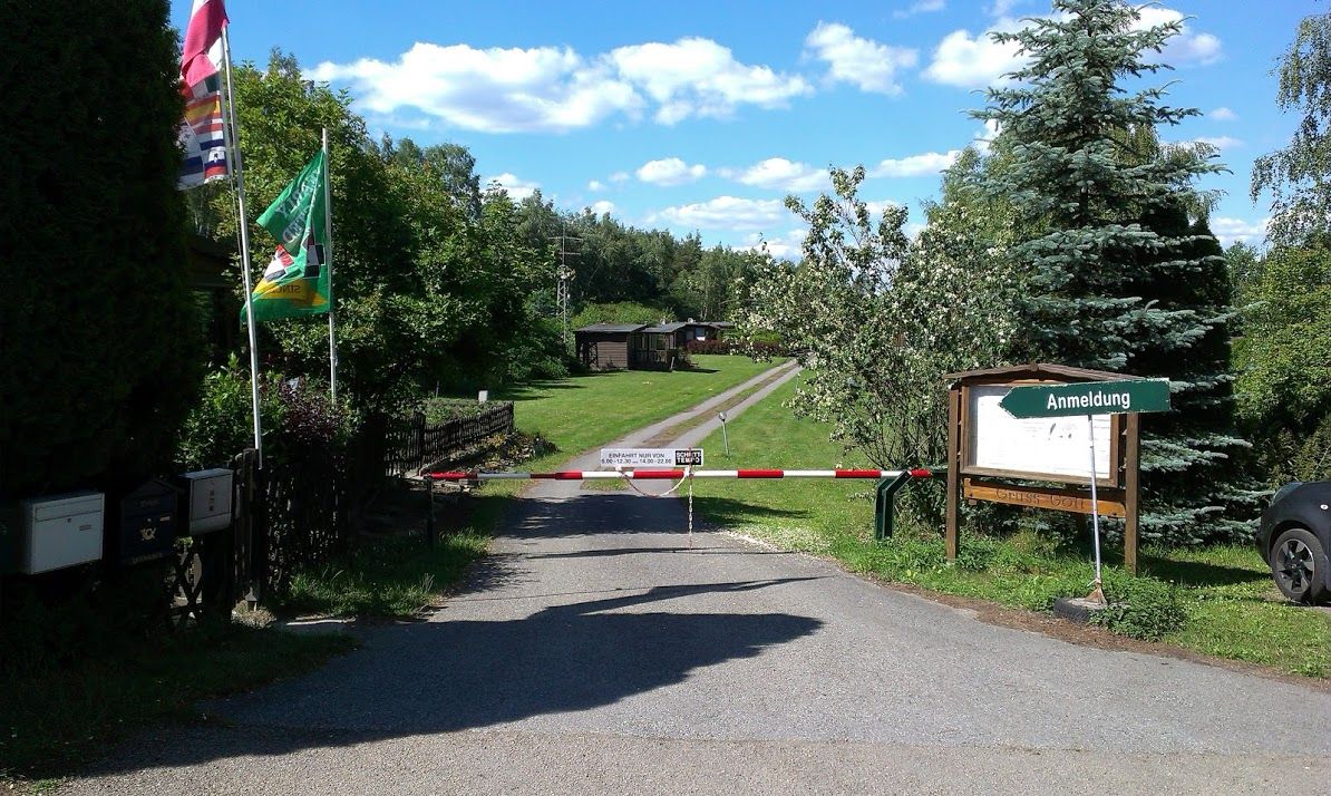 Eingang zu einem Campingplatz mit Schranke und Anmeldeschild.
