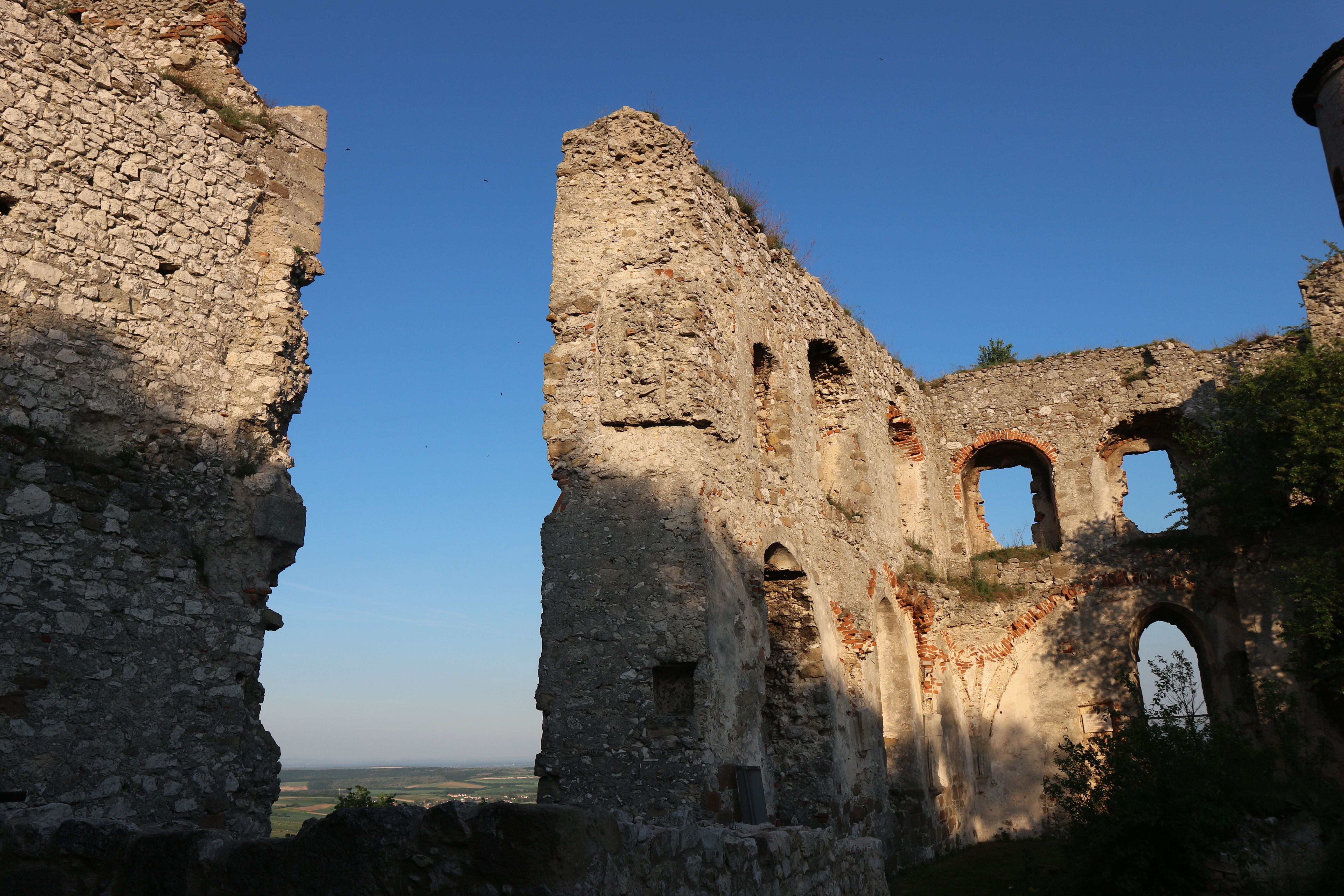 Ruinen der Burgruine Falkenstein bei Sonnenuntergang mit blauem Himmel.