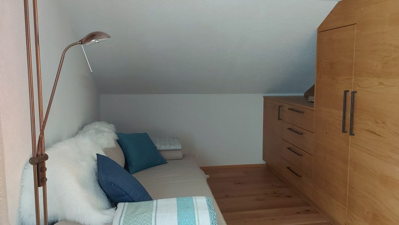 Doppelzimmer im Obergeschoss mit Ausziehcouch, Holzboden und Schrank.