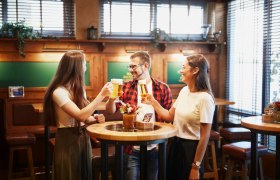 Drei Personen sto&szlig;en mit Biergl&auml;sern in der Zwickel-Stube an.