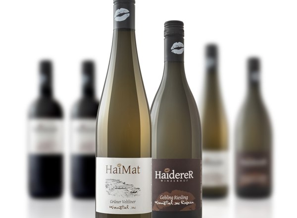 Zwei Weinflaschen im Vordergrund, unscharfe Flaschen im Hintergrund.