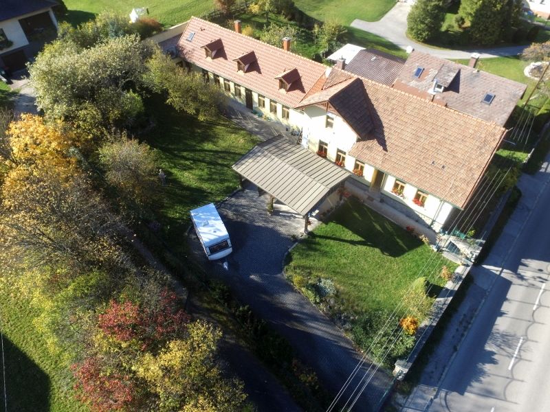 Luftaufnahme eines Hauses mit Garten und Ferienwohnungen im hinteren Teil.