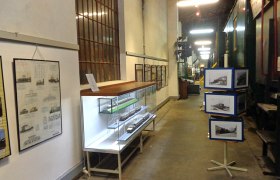 Innenansicht des Eisenbahnmuseums Schwechat mit Ausstellungsstücken und Informationstafeln.