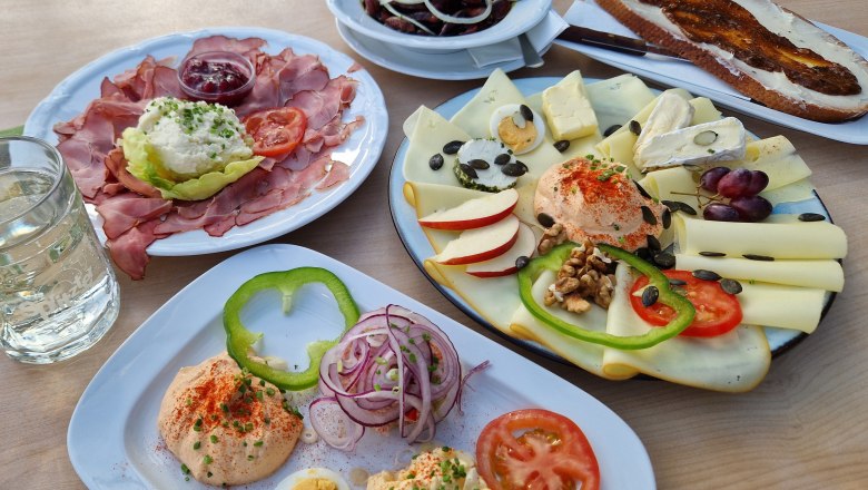 Verschiedene österreichische Heurigenjause-Gerichte auf einem Tisch.