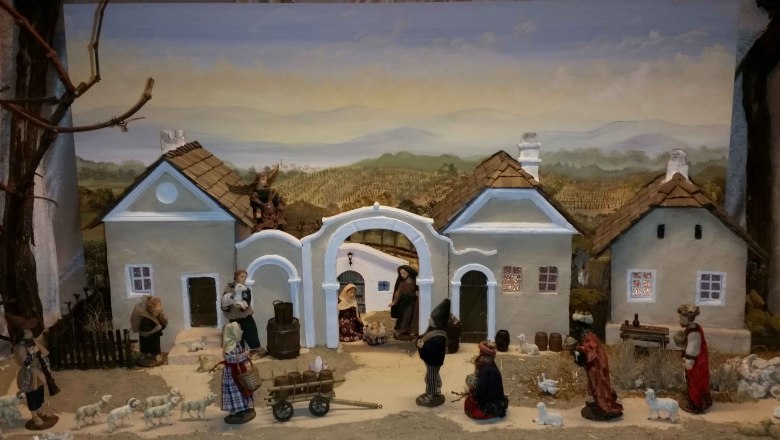 Weihnachtskrippe mit Figuren und Geb&auml;uden in l&auml;ndlicher Szenerie.