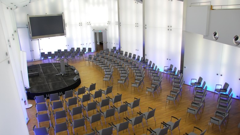Moderner Konferenzsaal mit Stuhlreihen und Bühne im Schloss Rothschild, Kristallsaal.
