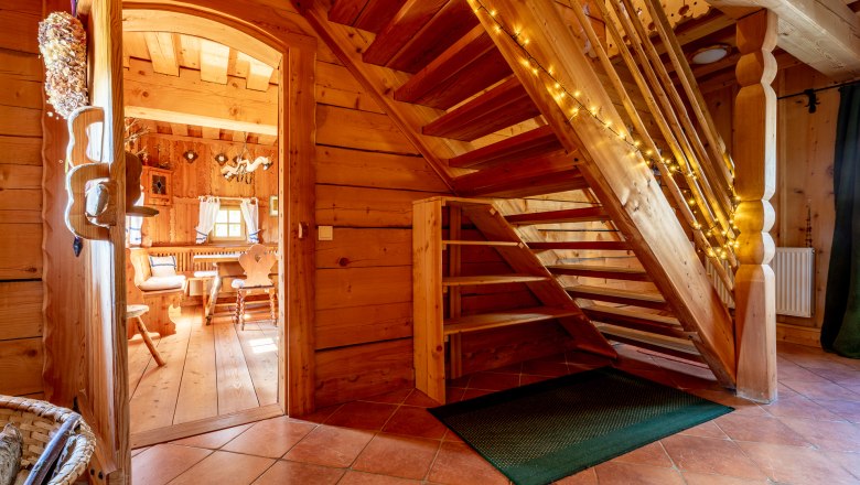 Holztreppe in einem Haum mit Holzvert&auml;felung mit Lichterkette dekoriert.