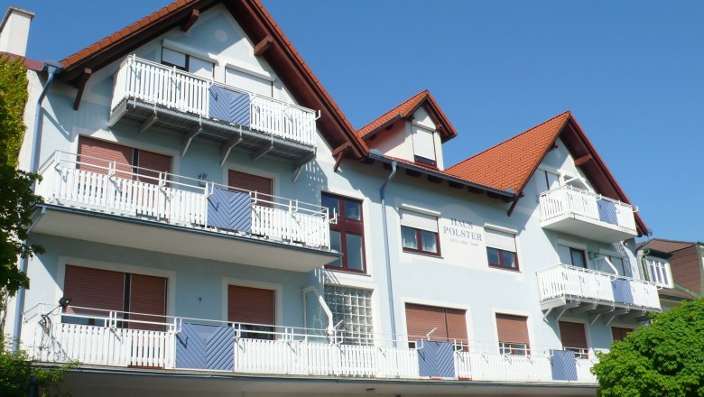 Haus, © Ferienwohnung Polster Mehrstöckiges Gebäude mit blauer Fassade und roten Dächern.